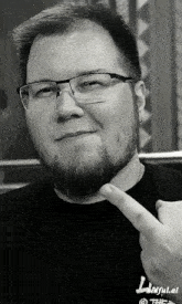 a man wearing glasses and a black shirt with the word faithful on the front