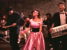 a woman in a pink top is dancing in a crowd