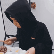 a man wearing a black hoodie and a headband that says seoul on it