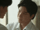 a man in a white shirt and tie is looking at another man in a white shirt and tie .