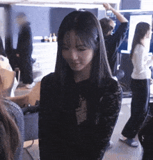 a woman in a black lace top is standing in a room