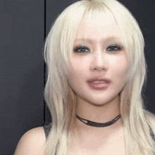 a woman with blonde hair and blue eyes is wearing a choker necklace