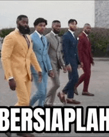 a group of men in suits walking in a line .
