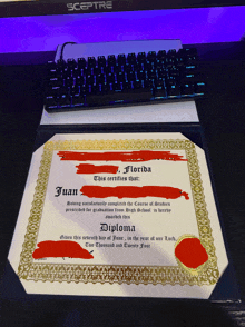 a diploma that says juan florida sits on a desk next to a keyboard