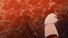 a person 's fist is visible in front of a brick wall