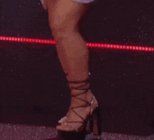 a close up of a woman 's feet wearing a pair of high heels
