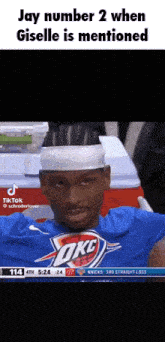 a basketball player wearing a headband and a blue shirt with the word okc on it