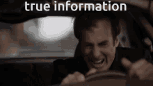 a man driving a car with the words true information written on the screen
