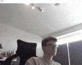 a boy wearing glasses is sitting in a noblechair