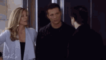 a man and a woman are standing next to each other in front of an elevator .