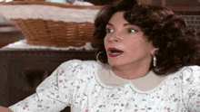 a woman with a surprised look on her face is wearing a white floral dress
