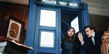 a man and a woman standing in front of a police public box