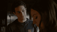 a man and a woman are standing next to each other and looking at each other .