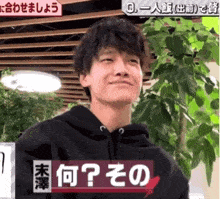 a man in a black hoodie with chinese writing on the bottom