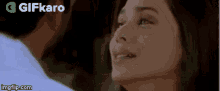 a man and a woman are looking at each other . the woman is crying and the man is smiling .