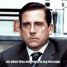 a man in a suit and tie is sitting in front of a sign that says me when they only react to my message