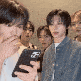 a group of young men are looking at a phone