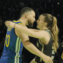 a basketball player with the number 10 on his jersey hugging another player
