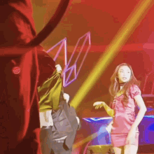 a woman in a red dress is dancing on a stage in front of a crowd