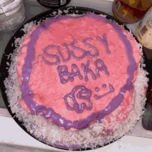 a pink cake with purple frosting that says sussy baka on it
