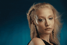 a woman with blonde hair and a nose ring looks at the camera