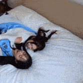 two girls are laying on a bed with one wearing a shirt that says ' a ' on it