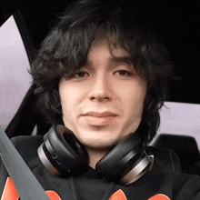 a man wearing headphones is sitting in a car with a seat belt around his neck