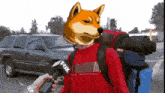 a man wearing a red shirt that says fox on it is talking into a microphone