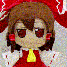 a close up of a stuffed doll with a yellow tie
