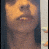 a close up of a woman 's face with a nose ring and a piercing in her lip .