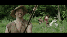 a man in a straw hat is smiling while holding a fishing rod