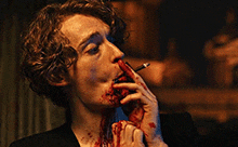 a man smoking a cigarette with blood coming out of his mouth