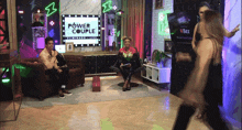 a man and woman are sitting in front of a power couple sign