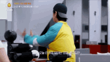 a man in a yellow vest is standing in front of a machine that says ' iland ' on it