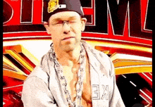 a man wearing a hat and glasses is standing in front of a sign that says wwe .