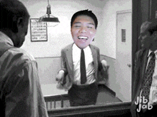a man in a suit and tie is smiling in front of a mirror with jib jab written on the bottom