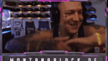 a man wearing headphones is smiling and pointing at the camera