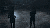 a woman is standing in front of a window in the dark .