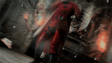 a man in a red suit with the letter r on the back