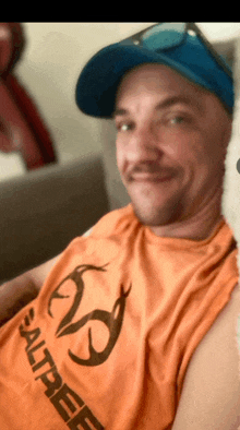 a man wearing an orange shirt that says salttree on it