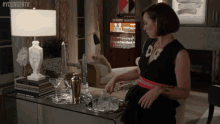 a woman in a black dress is pouring ice into a glass with the hashtag youngertv