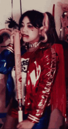 a woman dressed as harley quinn is holding a bat