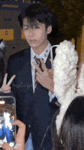 a man in a suit and tie is being photographed by a girl