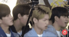 a group of young men are standing next to each other and looking at something .