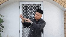 a man is standing in front of a white door with a mesh screen