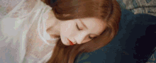 a woman in a white dress is laying on a bed with her eyes closed and red lipstick on her lips .