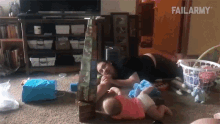 a man is laying on the floor with two babies and a stack of blocks that says failarmy on it