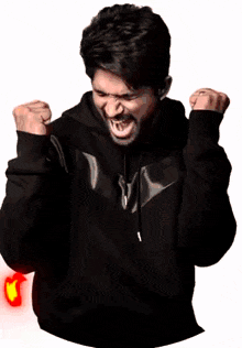 a man in a black jacket is surrounded by red flames and has the letter t on his chest
