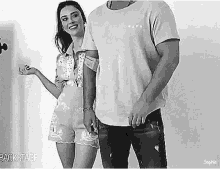 a man and a woman are standing next to each other .