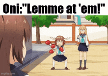 a girl with antlers is holding a pair of boxing gloves in front of another girl .